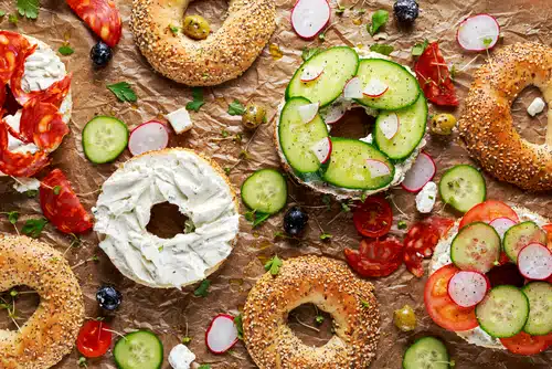 부드러운 치즈, 초리조, 야채를 곁들인 맛있는 베이글 샌드위치